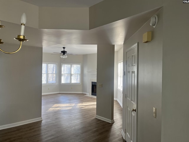 unfurnished living room featuring dark hardwood / wood-style floors and ceiling fan