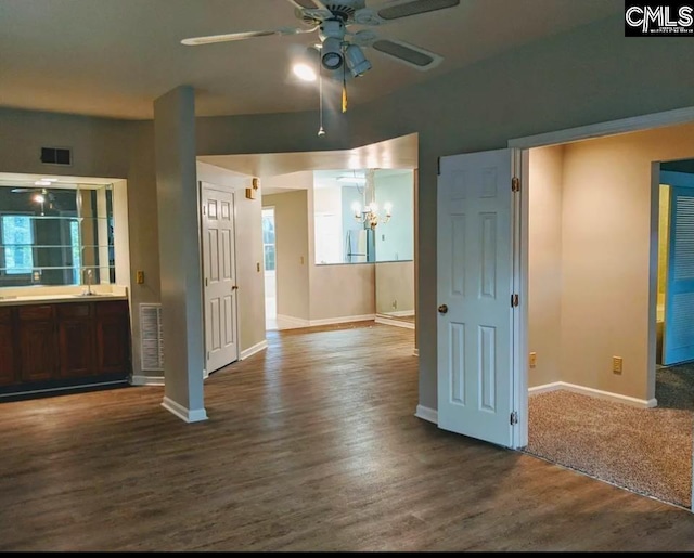 empty room with wood-type flooring, sink, and ceiling fan with notable chandelier