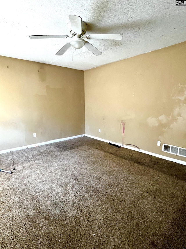 carpeted empty room with ceiling fan and a textured ceiling