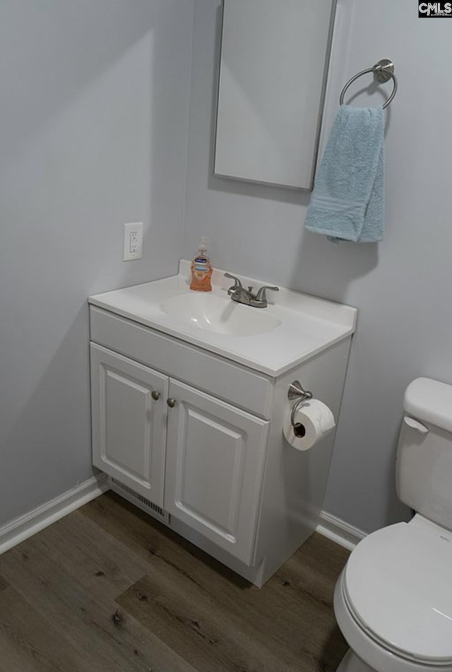 bathroom featuring vanity, wood-type flooring, and toilet