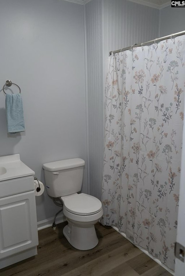 bathroom featuring vanity, crown molding, wood-type flooring, and toilet