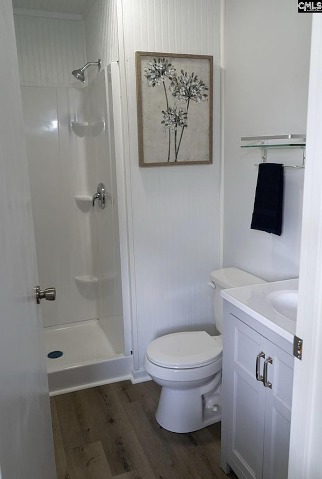 bathroom with vanity, wood-type flooring, toilet, and a shower