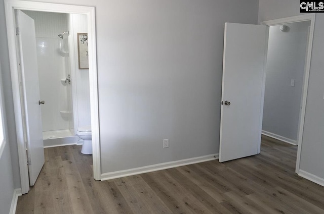 unfurnished bedroom featuring ensuite bath and light wood-type flooring