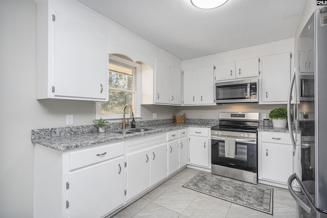 kitchen featuring appliances with stainless steel finishes, sink, and white cabinets