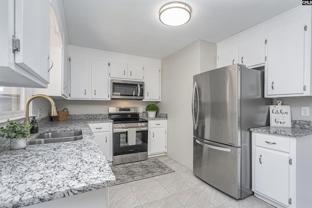 kitchen featuring white cabinetry, appliances with stainless steel finishes, sink, and a textured ceiling