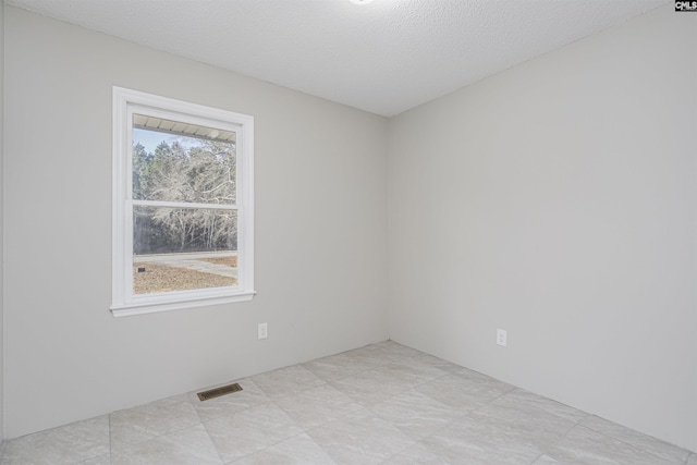 unfurnished room with a textured ceiling