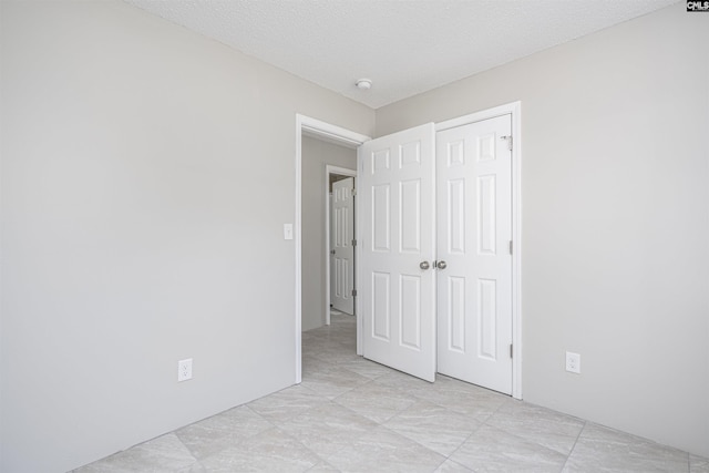 unfurnished bedroom featuring a closet and a textured ceiling