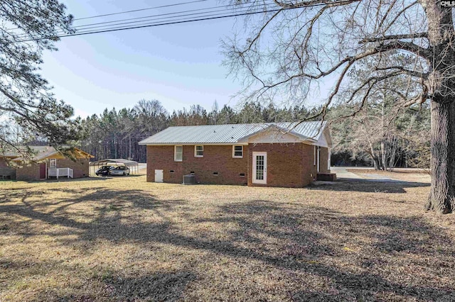 rear view of property featuring a carport, a yard, and cooling unit