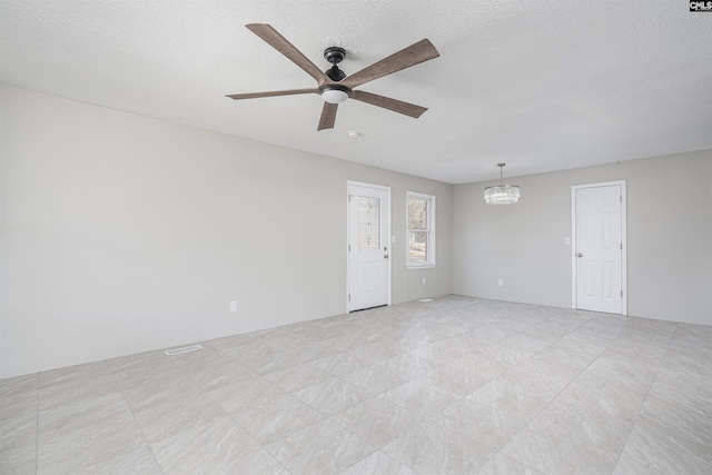 unfurnished room featuring ceiling fan with notable chandelier and a textured ceiling