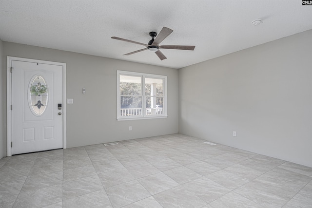 entryway with a textured ceiling and ceiling fan