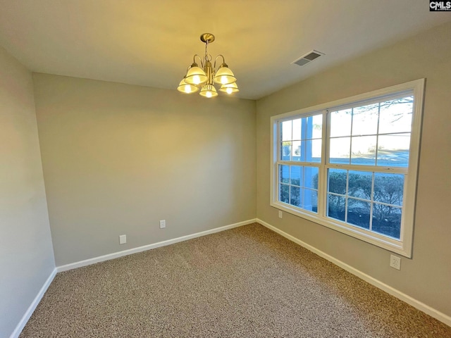 carpeted spare room with a chandelier