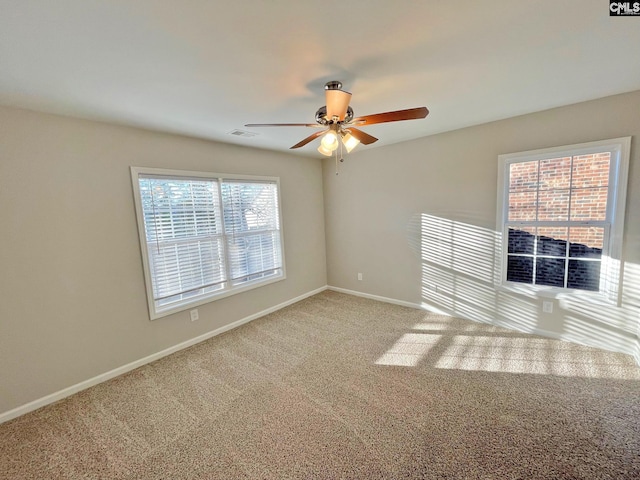 spare room featuring ceiling fan, a healthy amount of sunlight, and carpet