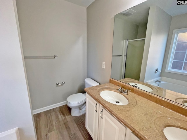 full bathroom featuring independent shower and bath, wood-type flooring, vanity, and toilet