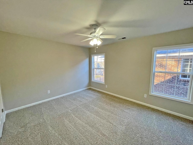 carpeted spare room featuring ceiling fan