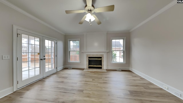 unfurnished living room featuring french doors, a high end fireplace, crown molding, and light hardwood / wood-style flooring