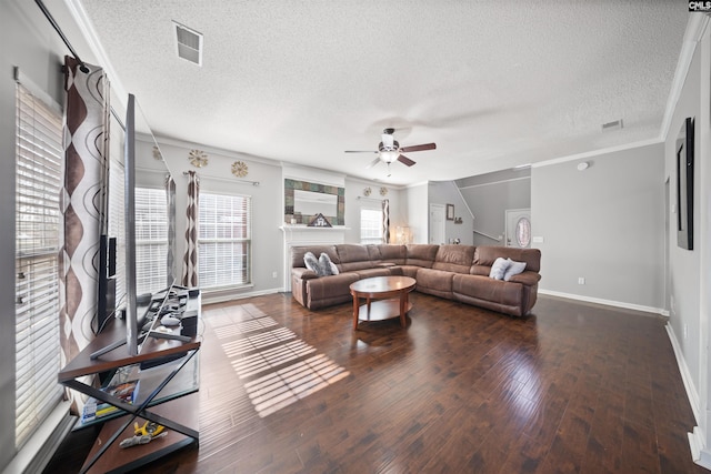 living room with dark hardwood / wood-style flooring, crown molding, ceiling fan, and a textured ceiling