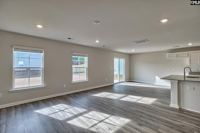 unfurnished living room featuring dark hardwood / wood-style floors and sink