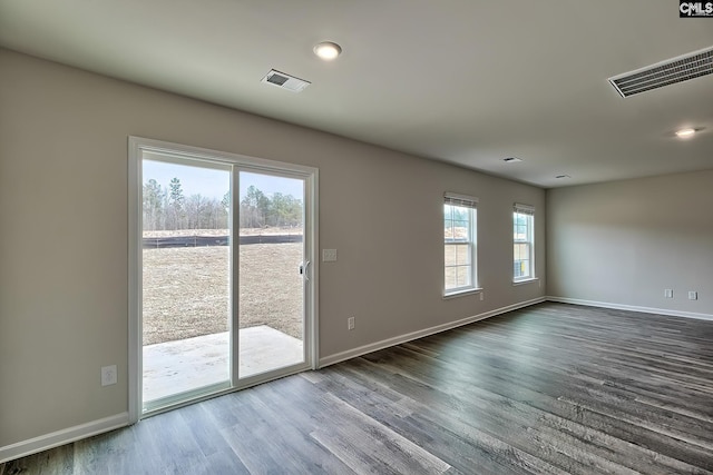 unfurnished room with wood-type flooring and a healthy amount of sunlight