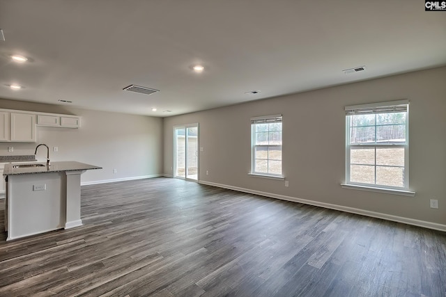 unfurnished living room with dark hardwood / wood-style flooring and sink