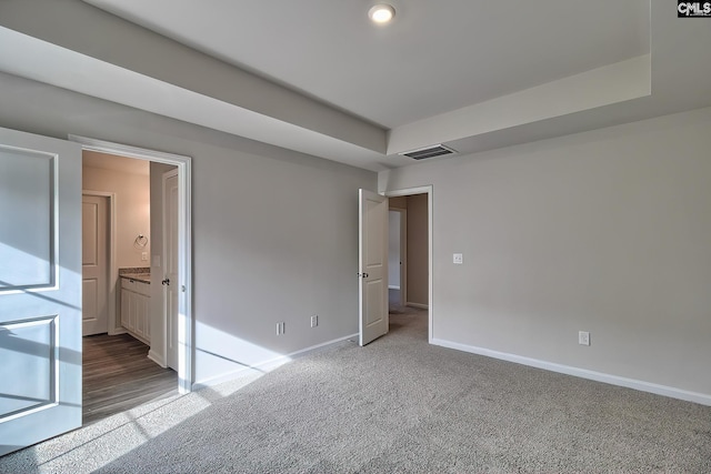 unfurnished room featuring carpet floors and a raised ceiling