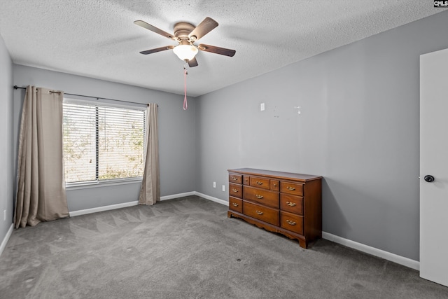 unfurnished bedroom featuring light carpet, a textured ceiling, and ceiling fan