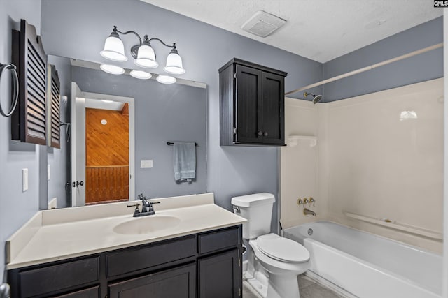 full bathroom with bathing tub / shower combination, tile patterned flooring, vanity, a textured ceiling, and toilet