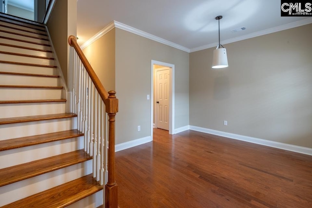 stairs with crown molding and wood-type flooring