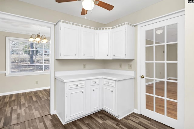 kitchen featuring white cabinetry, decorative light fixtures, ceiling fan with notable chandelier, and dark wood-type flooring