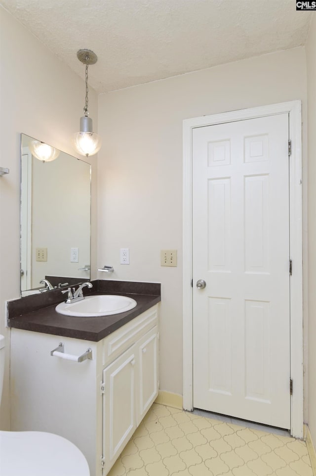 bathroom featuring tile patterned floors, vanity, and a textured ceiling