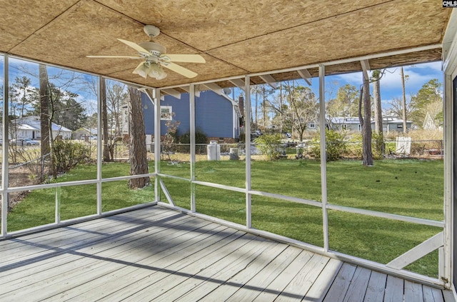 unfurnished sunroom featuring ceiling fan