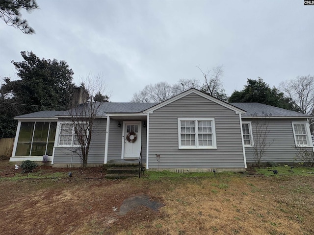 single story home featuring a front yard and a sunroom