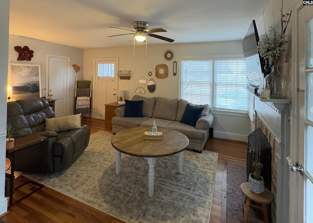 living room featuring dark wood-type flooring and ceiling fan