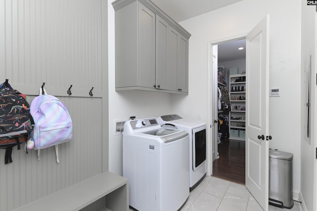 washroom featuring cabinets, washer and clothes dryer, and light tile patterned floors