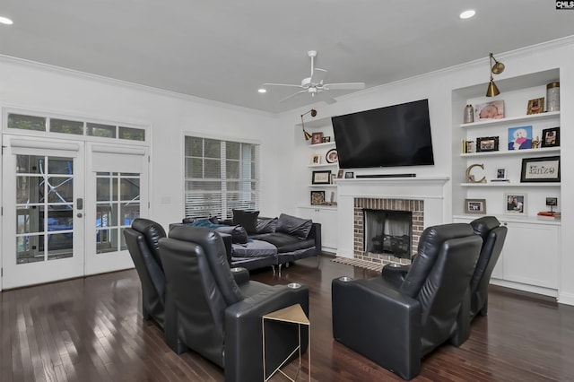 living room featuring dark hardwood / wood-style flooring, a brick fireplace, crown molding, and ceiling fan