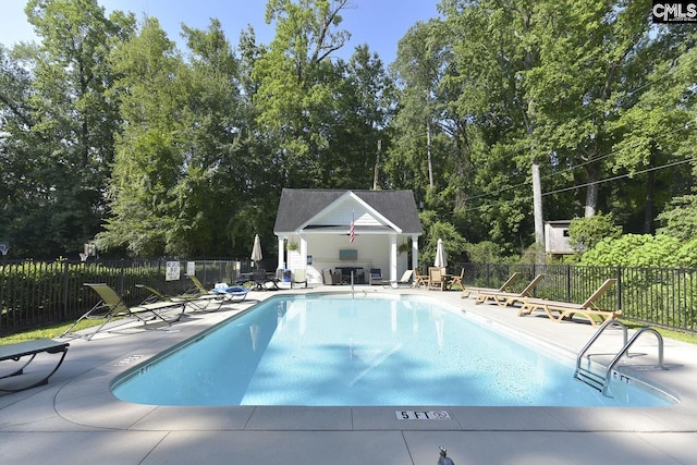 view of pool featuring an outbuilding and a patio