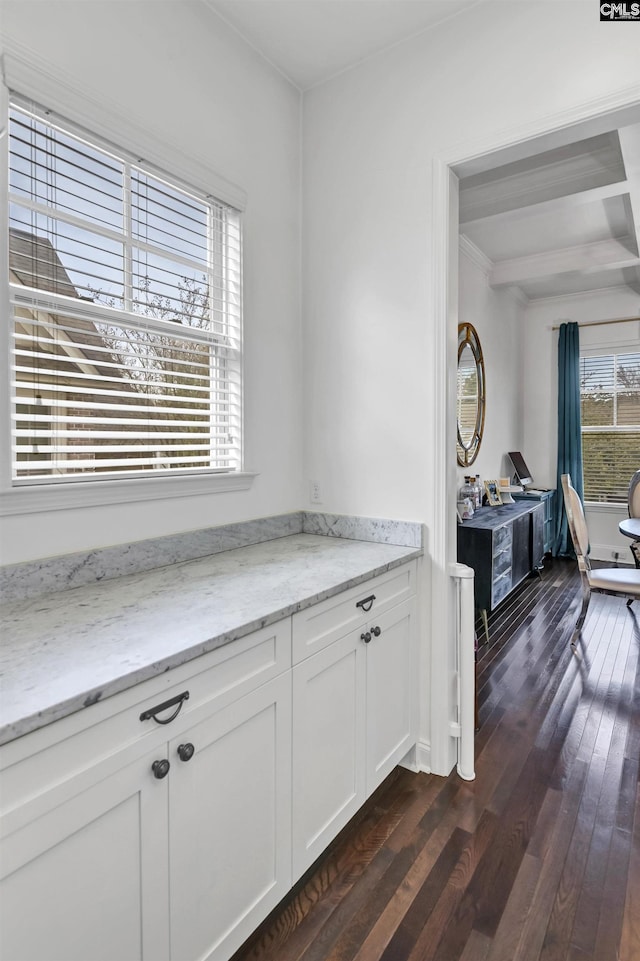 kitchen featuring beam ceiling, white cabinetry, light stone countertops, and dark hardwood / wood-style flooring