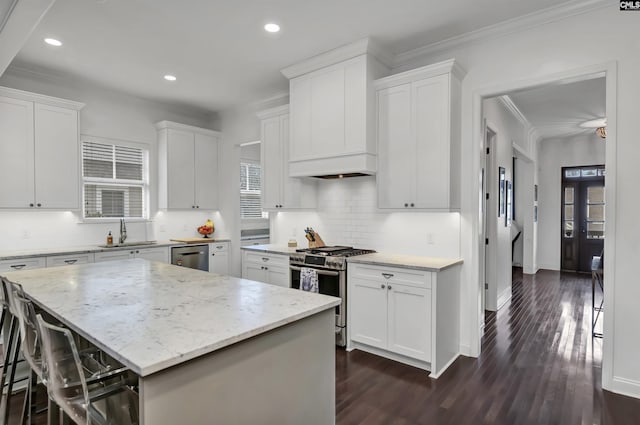 kitchen featuring sink, a kitchen island, white cabinets, and appliances with stainless steel finishes