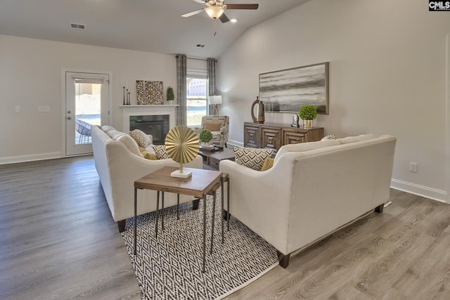 living room featuring hardwood / wood-style flooring, lofted ceiling, a healthy amount of sunlight, and ceiling fan