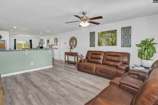 living room with light hardwood / wood-style flooring and ceiling fan