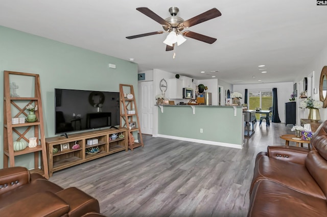 living room featuring ceiling fan and light wood-type flooring