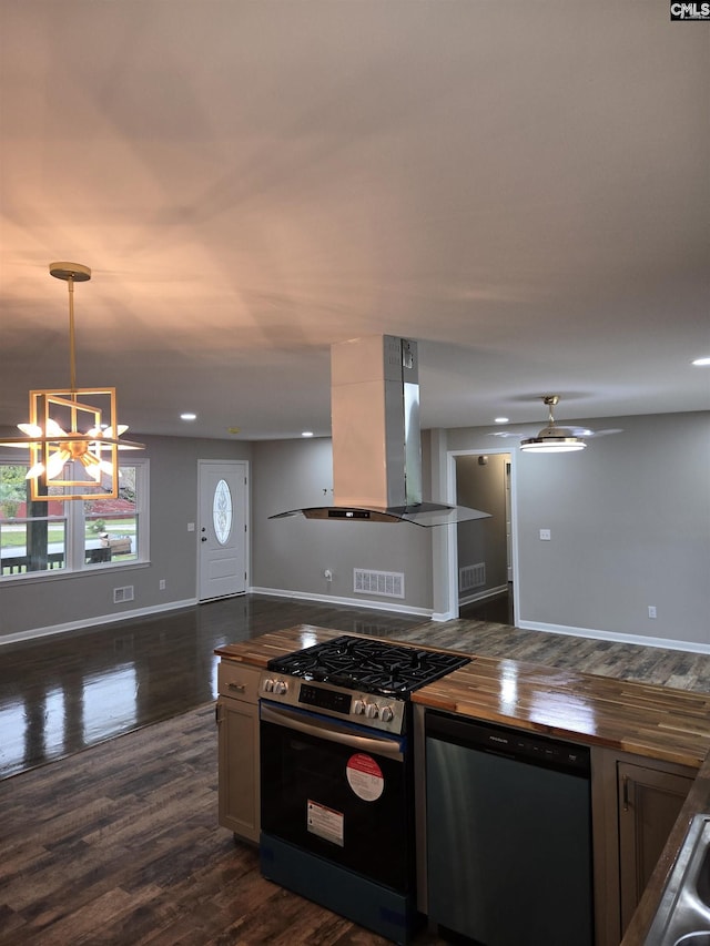 kitchen featuring decorative light fixtures, wooden counters, island exhaust hood, stainless steel appliances, and dark wood-type flooring