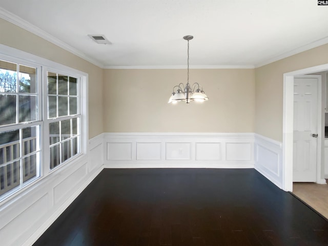 unfurnished dining area with crown molding, dark wood-type flooring, and a chandelier