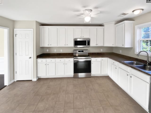 kitchen with white cabinetry, appliances with stainless steel finishes, sink, and ceiling fan