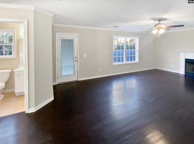 unfurnished living room with crown molding, dark hardwood / wood-style floors, and a healthy amount of sunlight