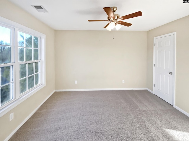 carpeted spare room featuring ceiling fan