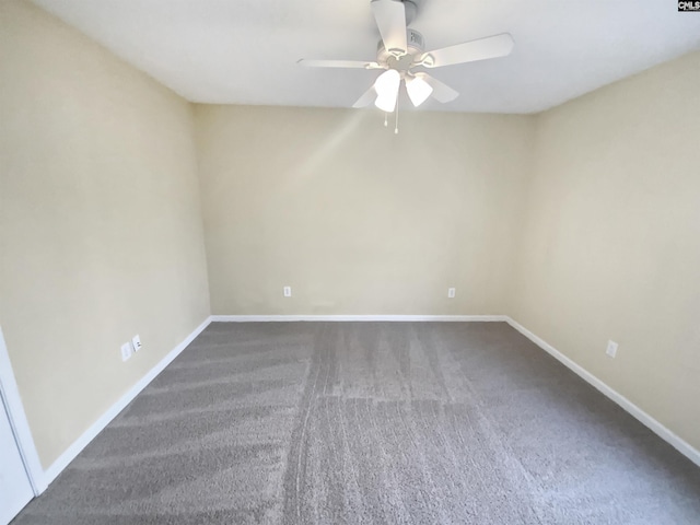 empty room featuring ceiling fan and dark carpet