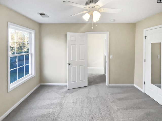 unfurnished room featuring light carpet and ceiling fan