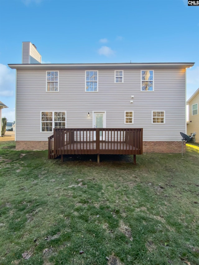 rear view of property with a wooden deck and a yard