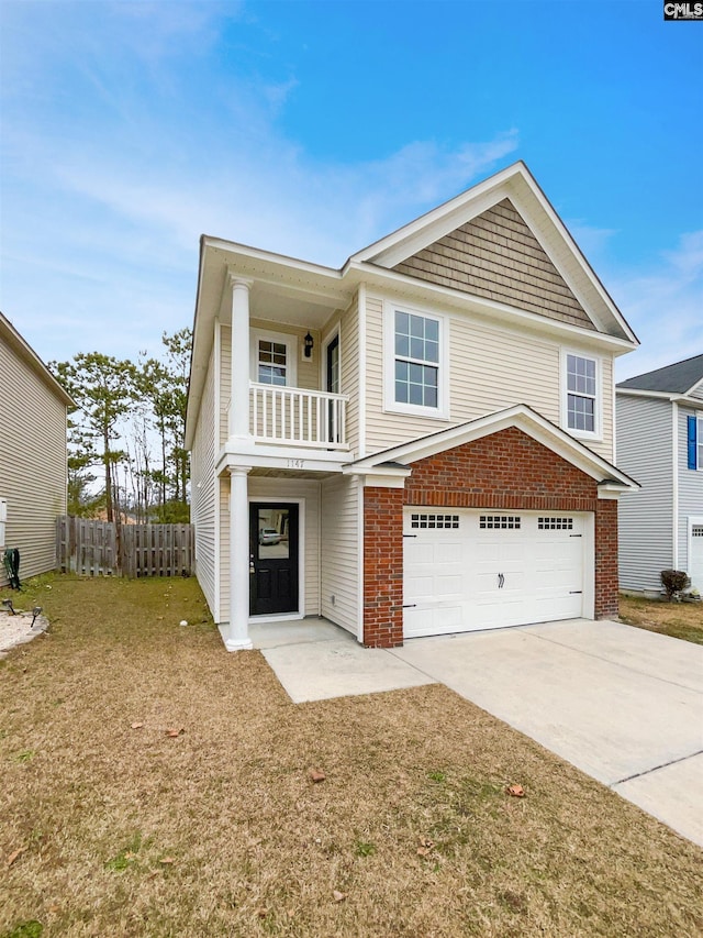 view of front of home featuring a garage, a balcony, and a front yard