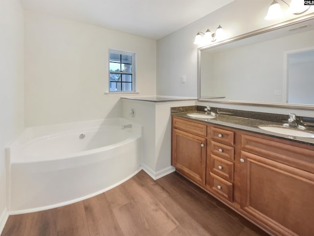 bathroom featuring hardwood / wood-style flooring, vanity, and a washtub